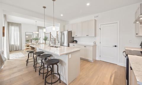 A wide, spacious kitchen with an island and room for a dining table.